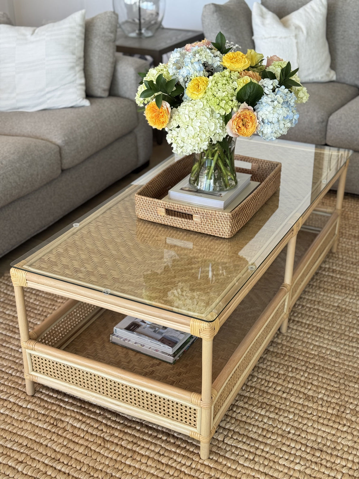 rattan tray on glass coffee table with hidden remotes
